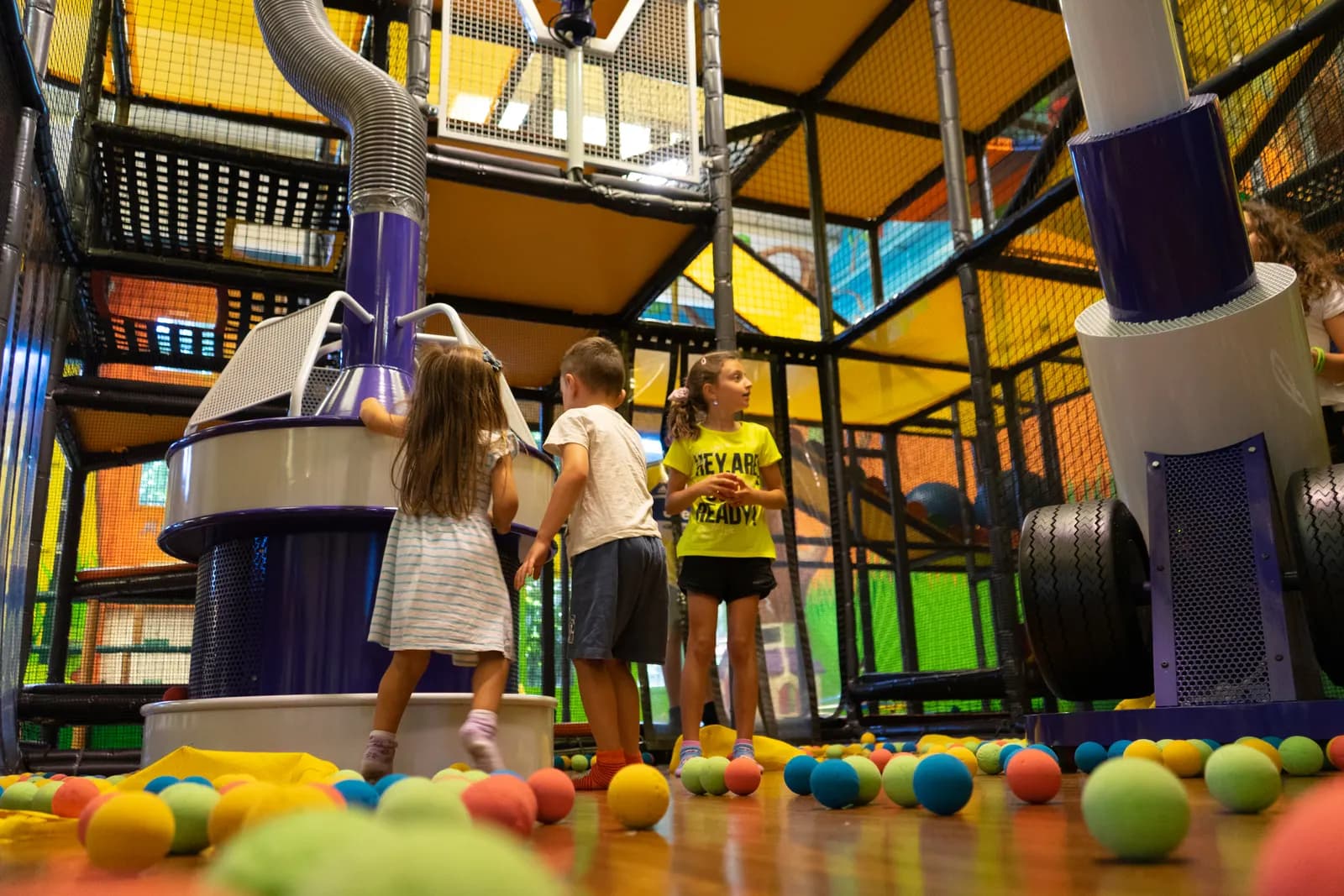 Bambini davanti ai cannoni ad aria con le palline sparse sul pavimento